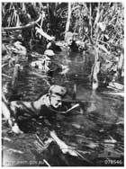1945年1月、フパイ河付近の深い沼地を進むオーストラリア軍偵察隊。連合軍は島南部のブインに集中していた日本軍主要部隊を目指して進攻したが、このように日本軍の潜伏地点する困難な地形の中での移動が行われた。