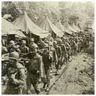 American infantry march out of camp to board their transports for the amphibious invasion of Hollandia, Dutch New Guinea, 16 April 1944.  The Americans landed at Hollandia and Aitape simultaneously on 22 April with the aim of bypassing the Japanese stronghold at Wewak and thus leaving the Japanese 18th Army isolated and cut off there.  The Japanese (who had expected the Allies to attack Wewak next) were taken by surprise and by the end of June the Americans had secured Aitape and Hollandia for minimal casualties.  At that point Aitape and the job of containing the Japanese 18th Army were handed over to the Australians while General MacArthur concentrated on developing Hollandia as the main American base for his planned invasion of the Philippines.