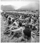 Native Carriers pause on the Kokoda Track in November 1942 to listen to a speech of congratulations from an Allied Officer