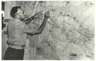 Intelligence Officer Captain N Owers studies a wall map in the Intelligence Room at Headquarters – New Guinea Force at Lae-Nadzab on 20 July 1944.