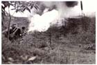 An Australian soldier of the 7th Division finishes off an 'enemy' foxhole during flame warfare exercises, Danbulla, Atherton Tableland, April 1945.  Beginning with the 9th Division in 1943 the Atherton Tablelands provided Australian units with the opportunity for large-scale and realistic tropical warfare training prior to deployment to the battlefields of New Guinea and Borneo.  Throughout 1944 and 1945 already experienced units returning from New Guinea were sent to Atherton to refit and acquire the latest techniques and equipment before returning to combat. 