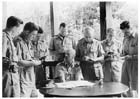 Major General Gordon Bennett (sitting) briefing war correspondents on the first clash between Australians and Japanese, Malaya, January 1942.  After the fall of Singapore and his return to Australia Bennett wrote a series of reports on the campaign that were circulated amongst Australian officers in Australia and New Guinea.  However their usefulness was limited as the terrain of Malaya bore little resemblance to the conditions encountered in New Guinea.